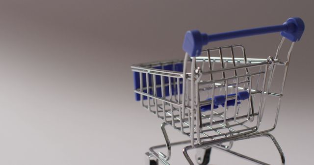 Empty blue shopping trolley on grey background - Download Free Stock Photos Pikwizard.com