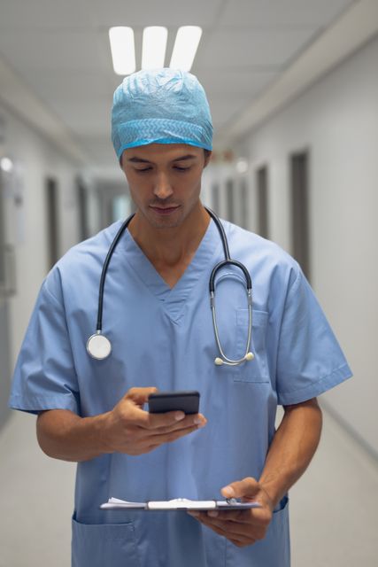 Male surgeon using mobile phone in the corridor - Download Free Stock Photos Pikwizard.com