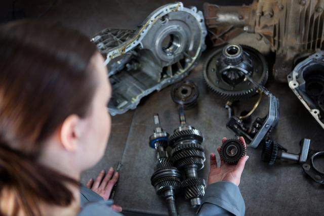 Female mechanic holding spare parts of car - Download Free Stock Photos Pikwizard.com
