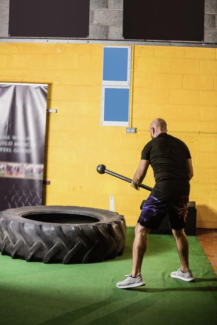 Thai boxer hitting tyre with sledge hammer - Download Free Stock Photos Pikwizard.com