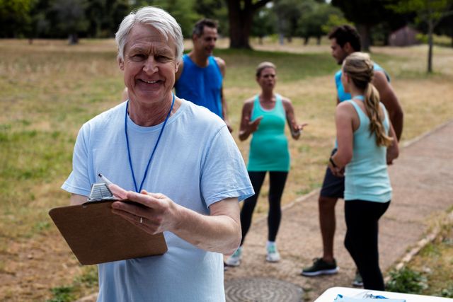 Portrait of male volunteer with clipboard in park