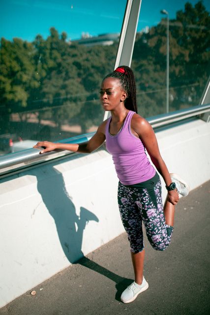 Fit african american woman stretching on bridge at sunset - Download Free Stock Photos Pikwizard.com