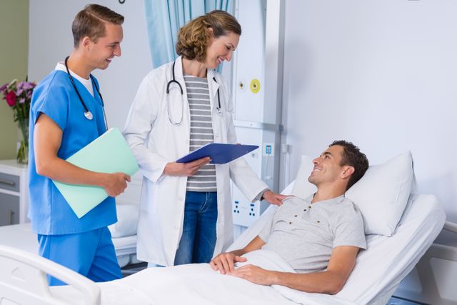 Doctors talking to patient in hospital bed - Download Free Stock Photos Pikwizard.com