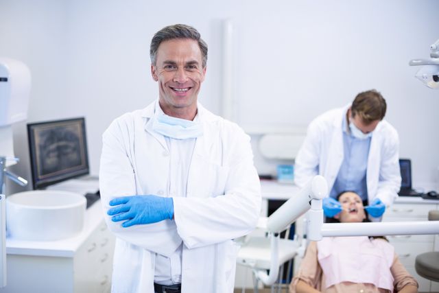 Smiling dentist standing with arms crossed - Download Free Stock Photos Pikwizard.com
