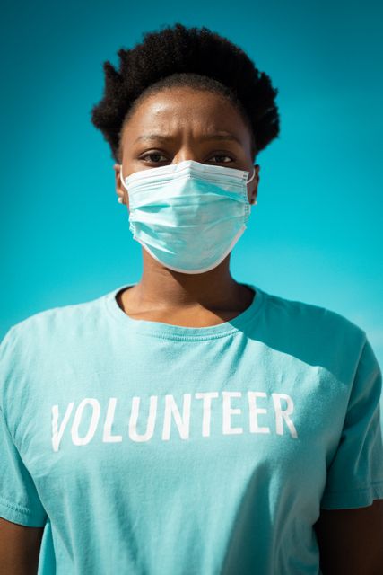 African american woman wearing volunteer t shirts and face mask, looking at camera - Download Free Stock Photos Pikwizard.com