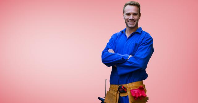 Handyman with tool belt standing with arms crossed against red background - Download Free Stock Photos Pikwizard.com