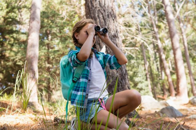 Girl looking through binoculars in the forest - Download Free Stock Photos Pikwizard.com
