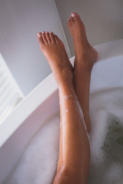 Legs of mixed race woman relaxing in the bath with her feet up - Download Free Stock Photos Pikwizard.com