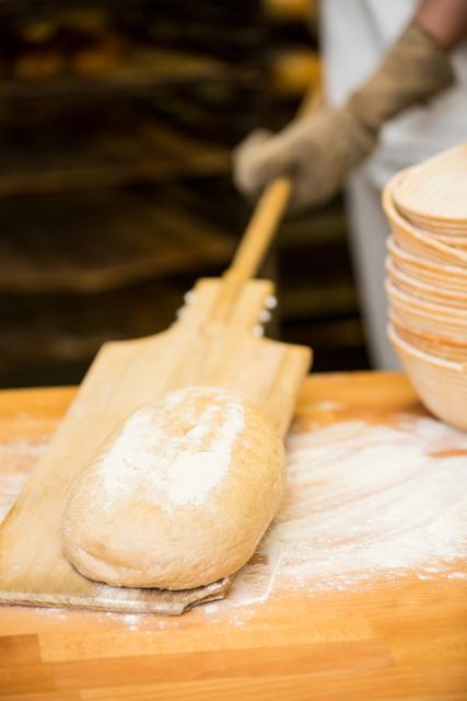 Baker lifting bread dough in wooden spoon - Download Free Stock Photos Pikwizard.com