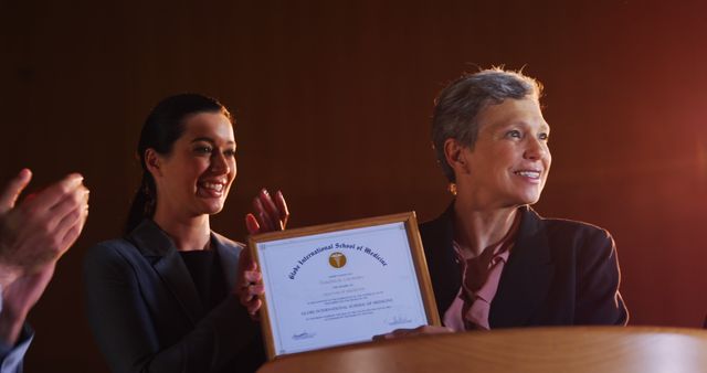 Female business executive receiving award at conference center