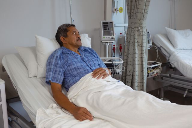 Mature male patient relaxing on bed in medical ward at hospital - Download Free Stock Photos Pikwizard.com