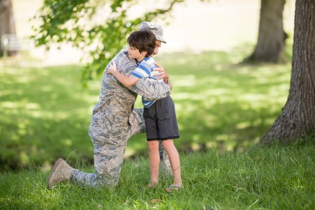 Army soldier embracing boy in park - Download Free Stock Photos Pikwizard.com