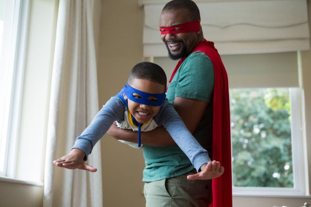 Son and father pretending to be a superhero at home - Download Free Stock Photos Pikwizard.com