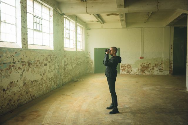 Young man taking a photo in warehouse - Download Free Stock Photos Pikwizard.com