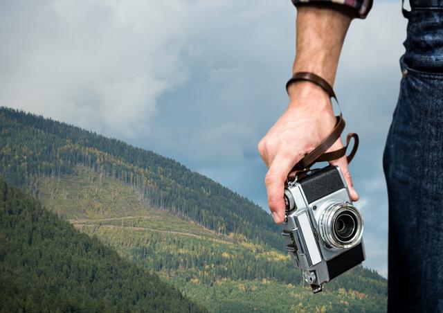 travel mountains. hand with camera in fron of a green mountain - Download Free Stock Photos Pikwizard.com