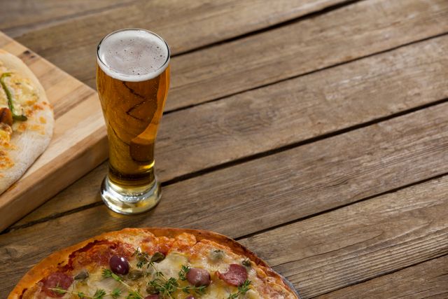 Delicious pizza served on wooden board with a glass of beer - Download Free Stock Photos Pikwizard.com