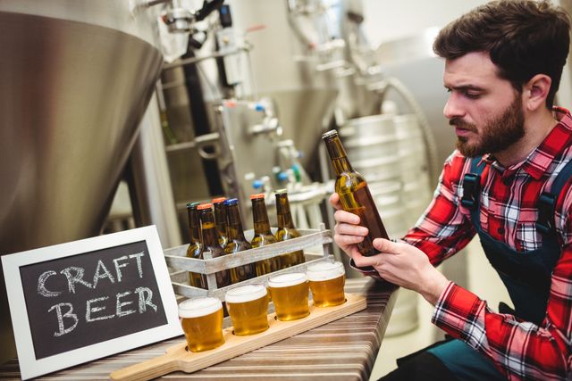Manufacturer examining beer in brewery - Download Free Stock Photos Pikwizard.com