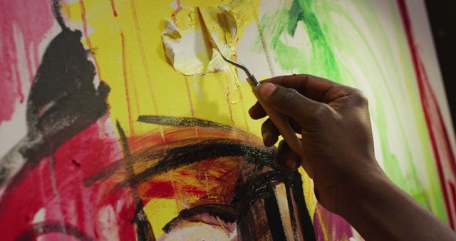 Close up of hand of male artist painting with palette knife on canvas at art studio. art, hobby and creative occupation concept