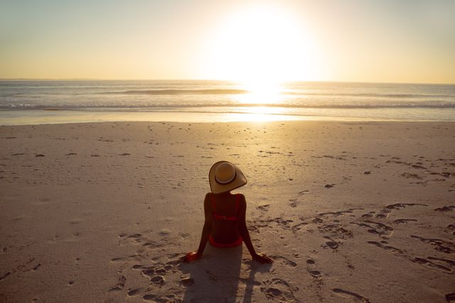 Woman in hat relaxing on the beach - Download Free Stock Photos Pikwizard.com