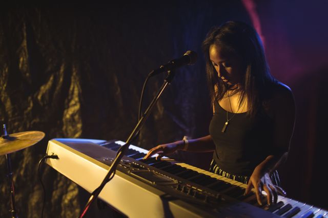 Musician playing piano in illuminated nightclub - Download Free Stock Photos Pikwizard.com