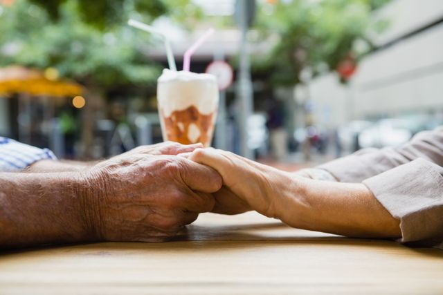 Senior couple holding hands in outdoor cafÃ© - Download Free Stock Photos Pikwizard.com