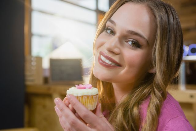 Portrait of beautiful woman holding cupcake - Download Free Stock Photos Pikwizard.com