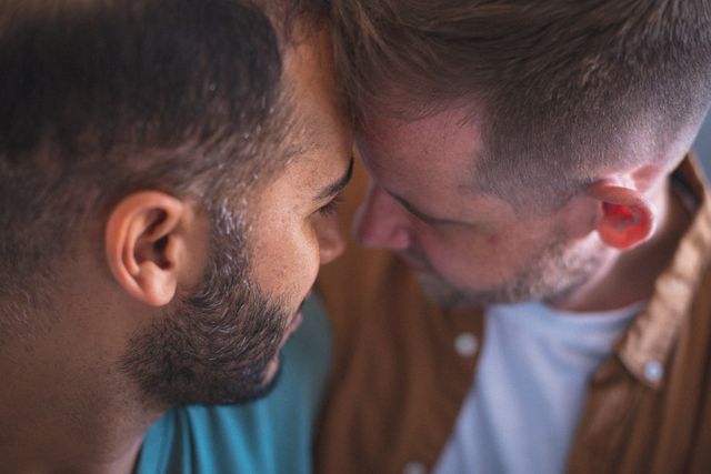 Diverse gay male couple embracing and smiling with heads together - Download Free Stock Photos Pikwizard.com