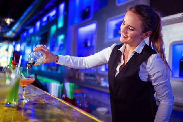 Beautiful bartender pouring drink in glass - Download Free Stock Photos Pikwizard.com