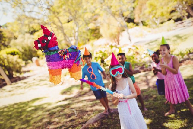 Little girl is going to broke the pinata for their birthday - Download Free Stock Photos Pikwizard.com