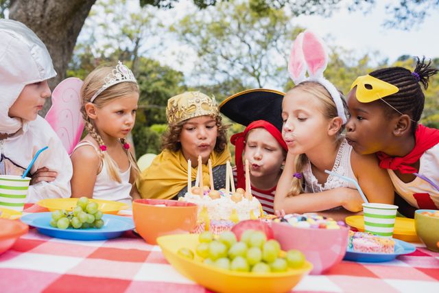  Cute children blowing together on the candle during a birthday party- Download Free Stock Photos Pikwizard.com
