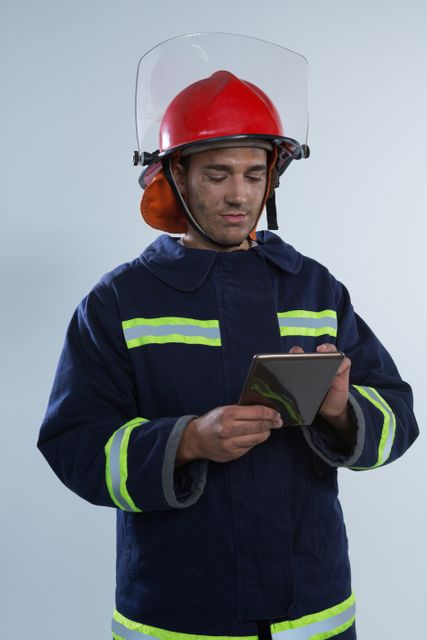 Fireman using digital tablet against white background - Download Free Stock Photos Pikwizard.com