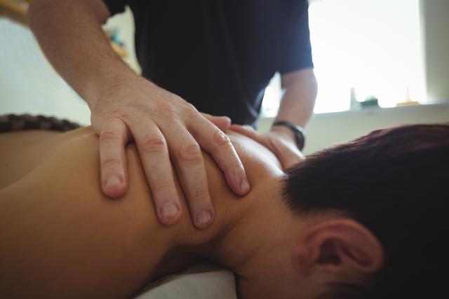 Man receiving shoulder massage from therapist - Download Free Stock Photos Pikwizard.com