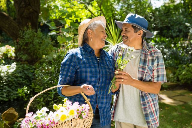 Senior couple walking in garden with flower basket  - Download Free Stock Photos Pikwizard.com