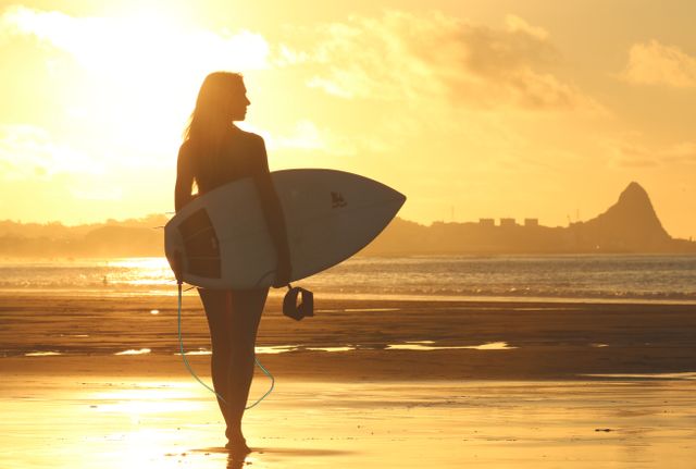 Woman Holding Surf Board Standing on Shoreline during Sunset - Download Free Stock Photos Pikwizard.com