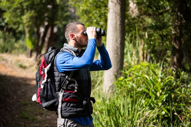 Male hiker looking through binoculars - Download Free Stock Photos Pikwizard.com