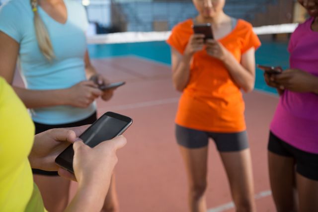 Female players using mobile phones in volleyball court - Download Free Stock Photos Pikwizard.com