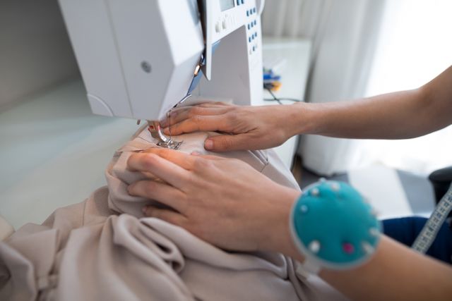 Fashion designer using sewing machine at home