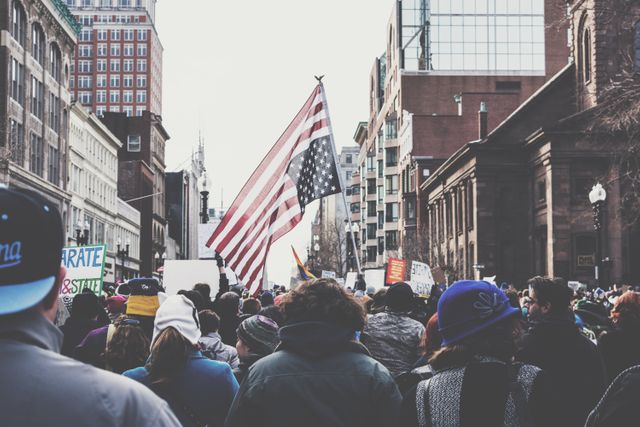 A crowd of protesters waving an upside-down American flag - Activism against different injustices that take place in our world and images capturing this will grow in popularity - Image