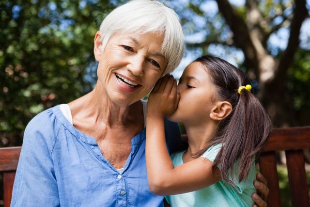 Girl whispering in ears of smiling grandmother - Download Free Stock Photos Pikwizard.com