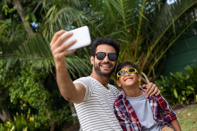 Father and son wearing sunglasses while taking selfie - Download Free Stock Photos Pikwizard.com