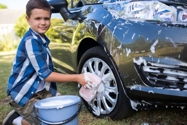 Teenage boy washing a car on a sunny day - Download Free Stock Photos Pikwizard.com