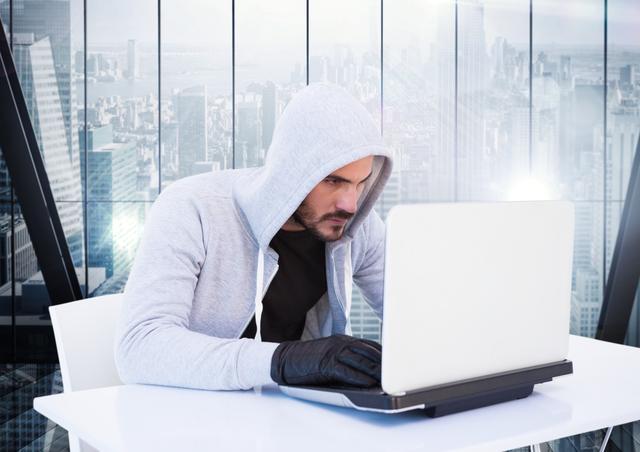 Criminal in hood with laptop in front of window - Download Free Stock Photos Pikwizard.com