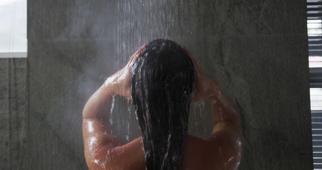 A woman washes her hair in a modern shower, captured in a slow-motion close-up. - Download Free Stock Photos Pikwizard.com