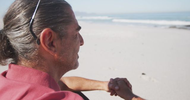 Happy senior caucasian man sitting on beach. Senior lifestyle, realxation, nature, free time and vacation.