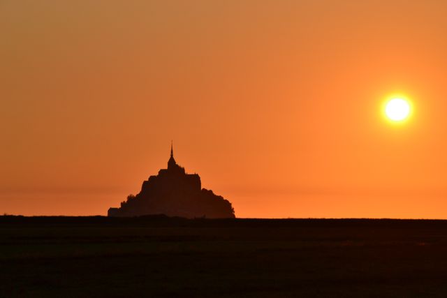 the sun setting over mont saint michel - Download Free Stock Photos Pikwizard.com