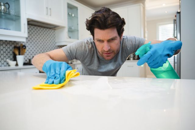 Man cleaning kitchen worktop at home - Download Free Stock Photos Pikwizard.com