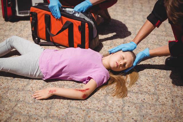 Paramedics examining injured girl - Download Free Stock Photos Pikwizard.com