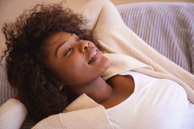 Smiling african american woman lying on couch, relaxing with eyes closed - Download Free Stock Photos Pikwizard.com
