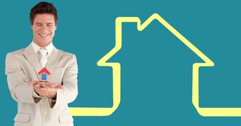 Businessman holding house model against house outline in background - Download Free Stock Photos Pikwizard.com