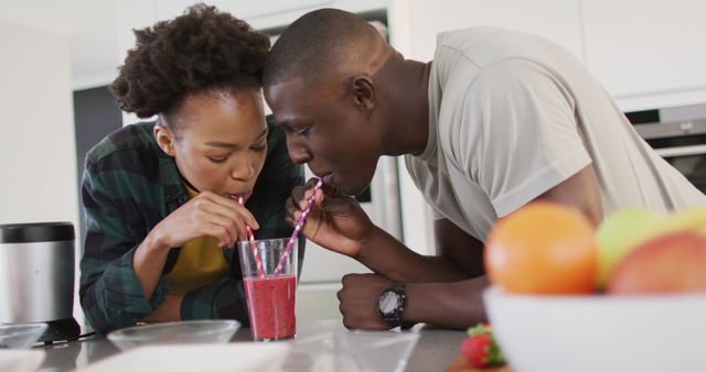 Image of happy african american couple drinking homemade juice from one glass with straws - Download Free Stock Photos Pikwizard.com